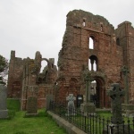 Lindisfarne gravestone and crumbling arches